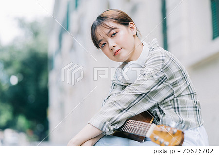 woman playing guitar on the street 70626702