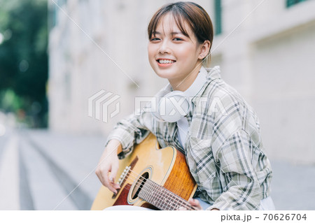 woman playing guitar on the street woman playing guitar on the street 70626704