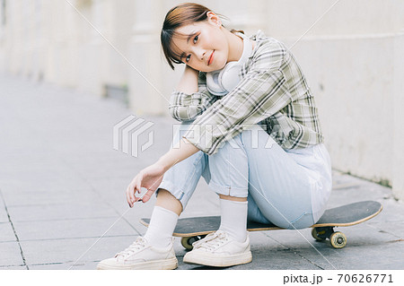 Girl learning to skateboard on the street, street activities Girl learning to skateboard on the street, street activities 70626771