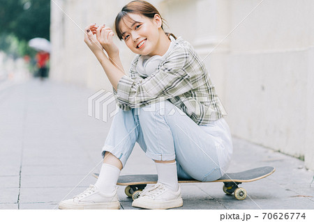 Girl learning to skateboard on the street, street activities 70626774