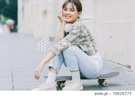 Girl learning to skateboard on the street, street activities 70626775