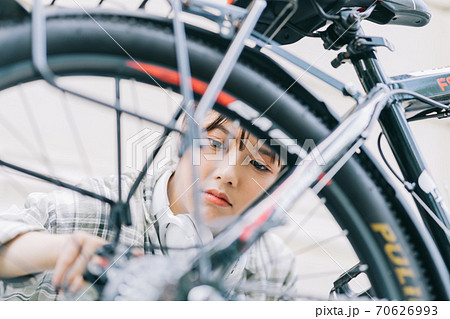 Woman self-repairs her bike 70626993