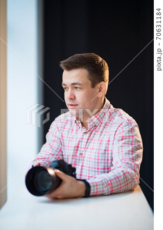 photographer holds a camera. creative profession. 70631184
