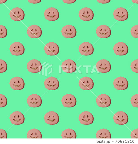 repeating pattern of sausage sandwiches with cut-out faces. A Halloween-style treat. Top view on a green background repeating pattern of sausage sandwiches with cut-out faces. A Halloween-style treat. Top view on a green background 70631810