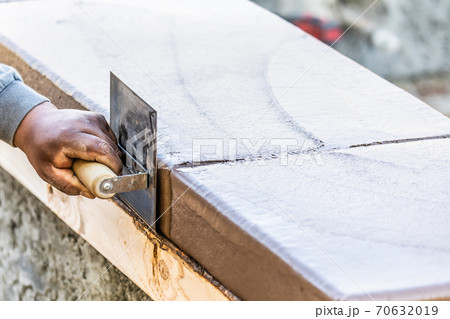 Construction Worker Using Stainless Steel Edger On Wet Cement Forming Coping Around New Pool 70632019