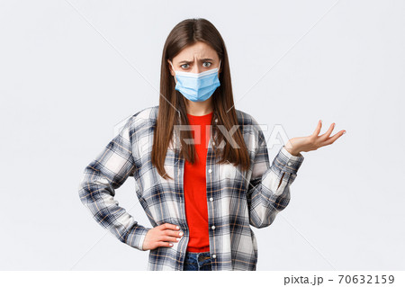 Coronavirus outbreak, leisure on quarantine, social distancing and emotions concept. Confused and bothered young woman cant understand this, shrug and stare puzzled camera, medical mask Coronavirus outbreak, leisure on quarantine, social distancing and emotions concept. Confused and bothered young woman cant understand this, shrug and stare puzzled camera, medical mask 70632159