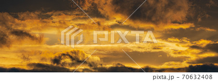 Panorama dramatic clouds illuminated rising of sun in sky to change weather. Natural meteorology background. Majestic cloudscape 70632408