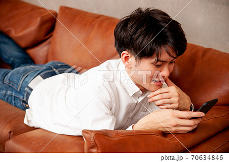 部屋でスマホをみる男性 部屋でスマホをみる男性 70634846
