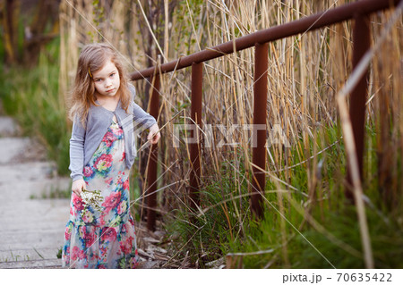 small girl standing on stairs with high handrail. small girl standing on stairs with high handrail. 70635422