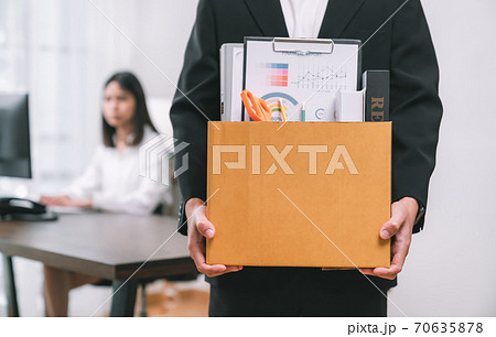 Businessman packaging and holding brown cardboard box because fired from work. Businessman packaging and holding brown cardboard box because fired from work. 70635878