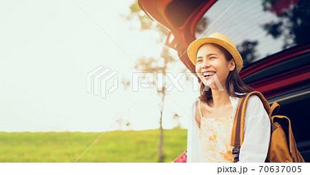 Happy young Asian woman wearing a hat and smiling with sitting on a back car, travel in the summer Happy young Asian woman wearing a hat and smiling with sitting on a back car, travel in the summer 70637005