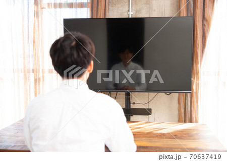 部屋でテレビを見て過ごす男性 70637419