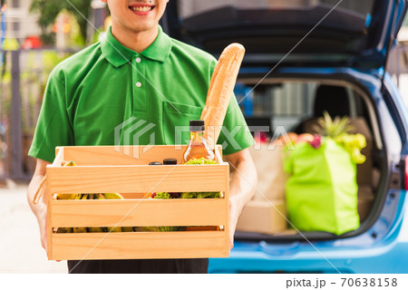 Delivery man grocery prepare fresh vegetables food in wooden basket on back car Delivery man grocery prepare fresh vegetables food in wooden basket on back car 70638158