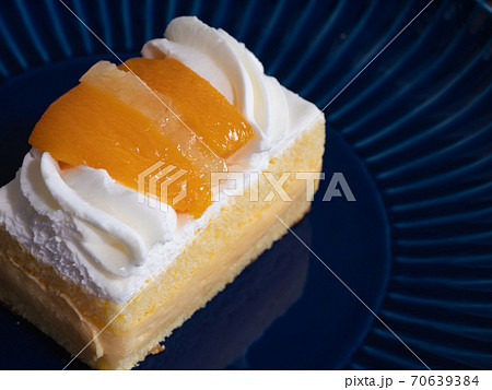 黄桃とパインとホイップクリームがトッピングされたショートケーキのクローズアップ の写真素材