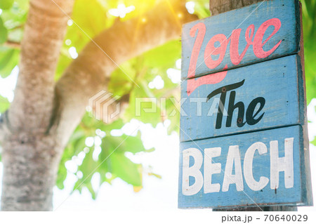 Love the beach word on wood board hang on tree beside summer beach. Love the beach word on wood board hang on tree beside summer beach. 70640029