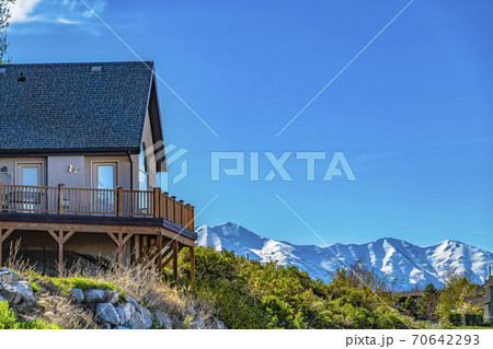 House on a hill with balcony overlooking snowy mountain and bright blue sky House on a hill with balcony overlooking snowy mountain and bright blue sky 70642293