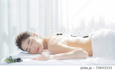 横になってマッサージを受ける美人女性 70643333