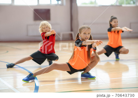 Three kids exercising in the gym and looking concentrated 70643730