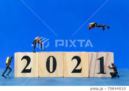 Miniature divers diving around wooden block 2021 , Happy new Year concept 70644010