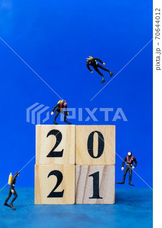 Miniature divers diving around wooden block 2021 , Happy new Year concept Miniature divers diving around wooden block 2021 , Happy new Year concept 70644012