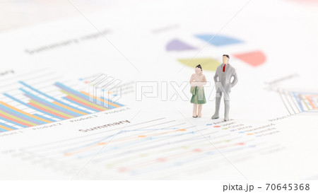 Miniature figures businessman standing on a graph chart Miniature figures businessman standing on a graph chart 70645368