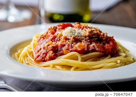 Pasta with meat and tomato sauce on wooden table. 70647047