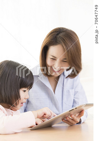 タブレットPCを見る親子 タブレットPCを見る親子 70647749