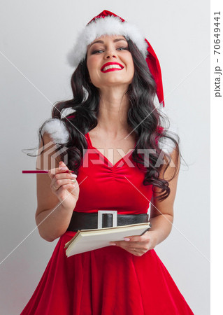 Santa girl with wish list and pencil Santa girl with wish list and pencil 70649441