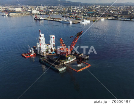 秋の北海道函館市函館港でしゅんせつ工事中のクレーン船の風景を空撮 秋の北海道函館市函館港でしゅんせつ工事中のクレーン船の風景を空撮 70650497