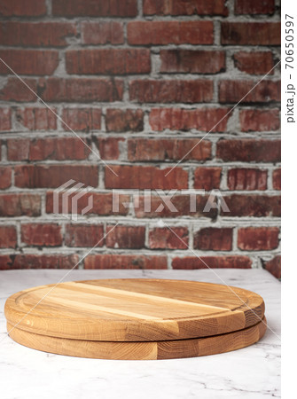 empty round wooden cutting board against brown brick wall background empty round wooden cutting board against brown brick wall background 70650597