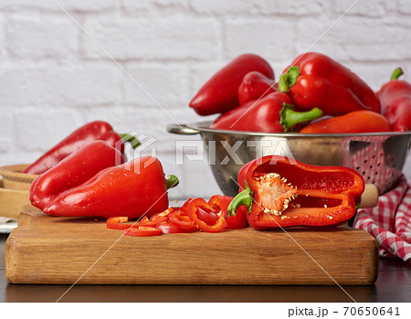 sliced red pepper on a cutting wooden board 70650641