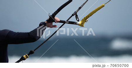 Man kitesurfer ready for kite surfing rides in blue sea 70650700
