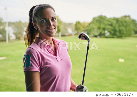 Sportswoman holding an iron club with a gloved hand 70651277