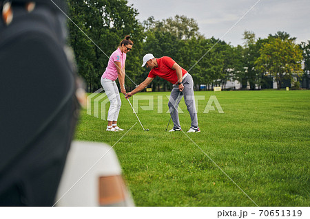 Experienced male tutor instructing a female beginner 70651319
