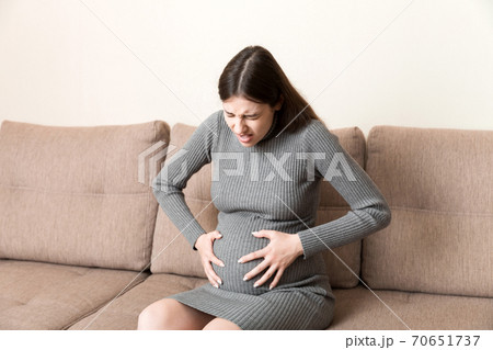 Pregnant Lady Having Massaging Lower Belly Sitting on Sofa Indoor. Pregnancy  Problems Concept Stock Photo - Image of massaging, contractions: 199197090