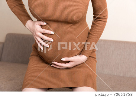 Pregnant Lady Having Massaging Lower belly Sitting On Sofa Indoor. Pregnancy Problems Concept. Maternity healthcare Pregnant Lady Having Massaging Lower belly Sitting On Sofa Indoor. Pregnancy Problems Concept. Maternity healthcare 70651758