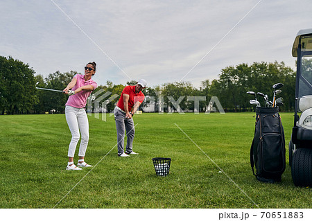 Beginner golfer and her coach training together 70651883