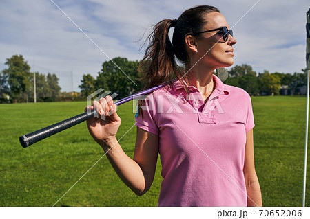 Serene golfer in a polo shirt standing outdoors 70652006