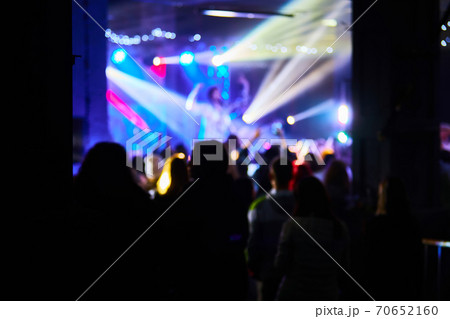 Music Concert background blur. Blurred People dancing with original bokeh lights in background - Defocused image for an artistic touch of disco club - Concept of nightlife with music and entertainment 70652160