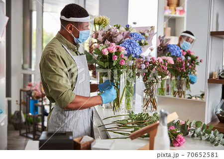 Young handsome man working in flower shop 70652581