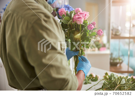 Shop assistant holding bunch of pink roses 70652582