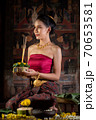Thai girl in traditional dress costume making and decorating Krathong. Loy Krathong Festival. 70653581
