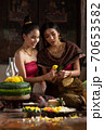 Two thai woman in traditional dress costume making and decorating Krathong. Loy Krathong Festival. 70653582