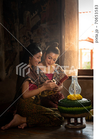 Two thai woman in traditional dress costume making and decorating Krathong. Loy Krathong Festival. Two thai woman in traditional dress costume making and decorating Krathong. Loy Krathong Festival. 70653583