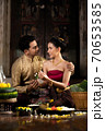 Thai couple in traditional dress costume making and decorating Krathong. Loy Krathong Festival. 70653585