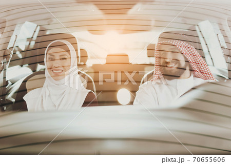 Husband and wife are sitting in a car and smiling. 70655606
