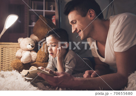 Father and son are reading fairy tales book. 70655680