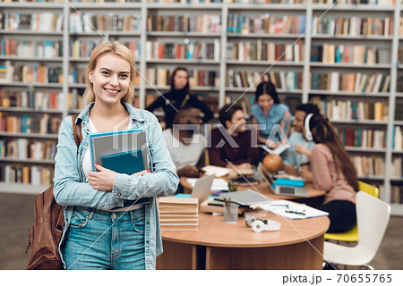 Beautiful girl holds textbooks in her hands. Beautiful girl holds textbooks in her hands. 70655765