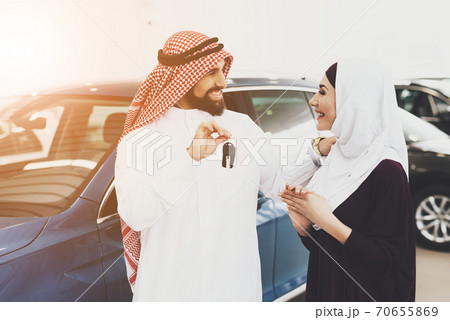 A man holds keys and smiles while makes a gift. 70655869