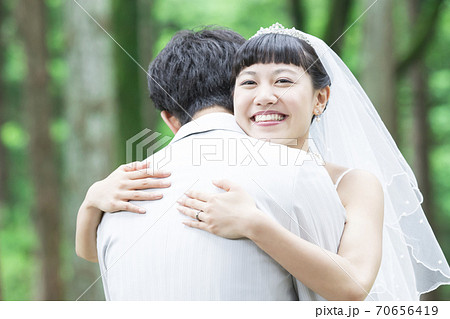 抱きしめる新郎新婦 70656419